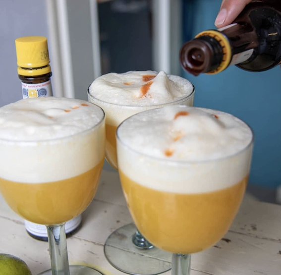 Cóctel Pisco Maracuyá servido en copa con pulpa de maracuyá