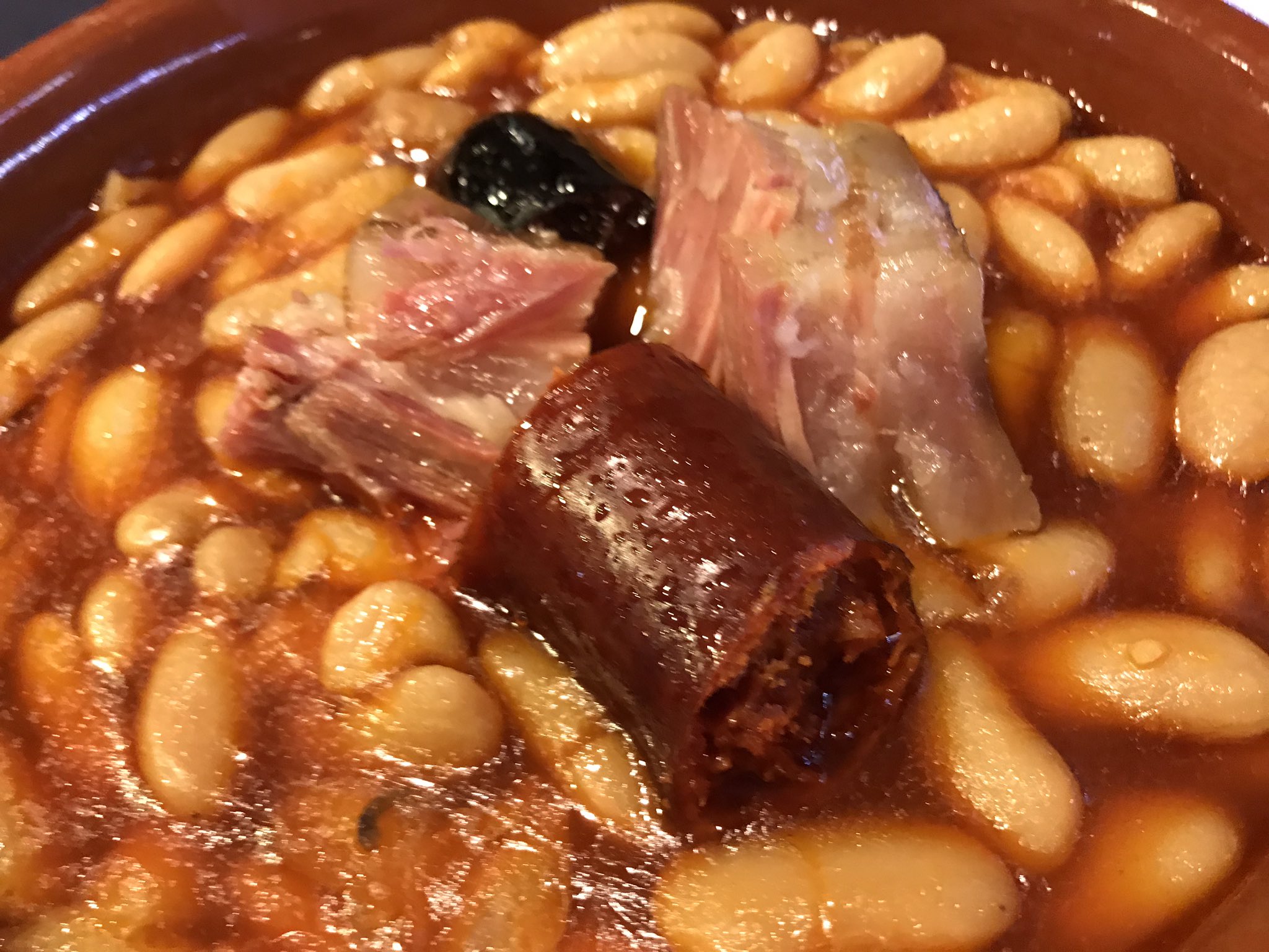 Plato de fabada asturiana humeante con embutidos