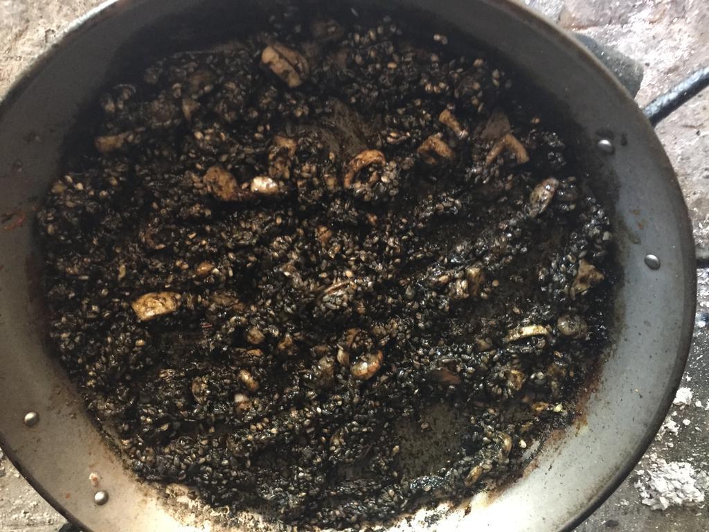 Nacarando el arroz en el sofrito con tinta