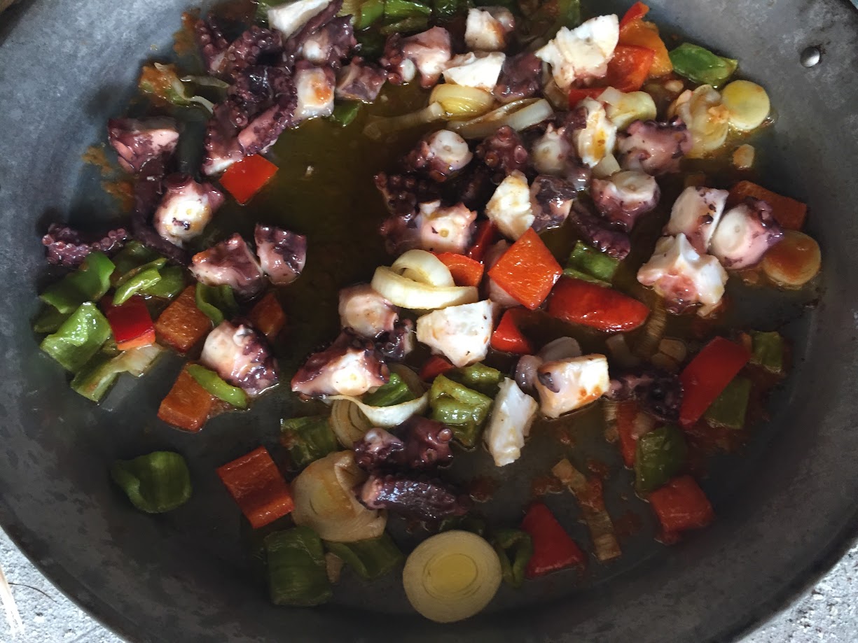 Arroz con pulpo y ajos tiernos durante la cocción