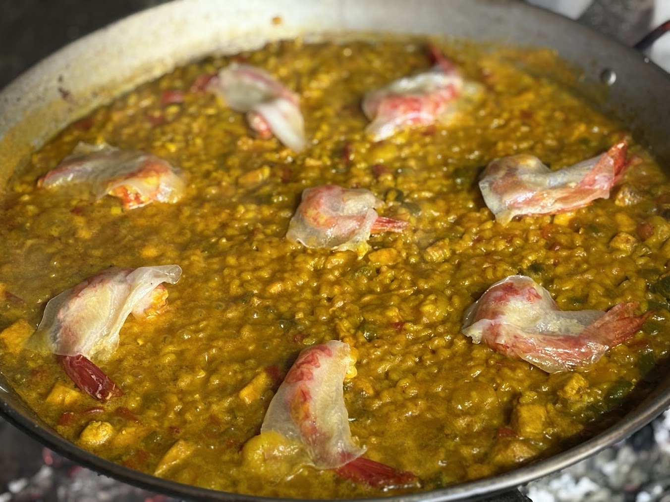Paella terminada de gamba roja, guanciale y rape