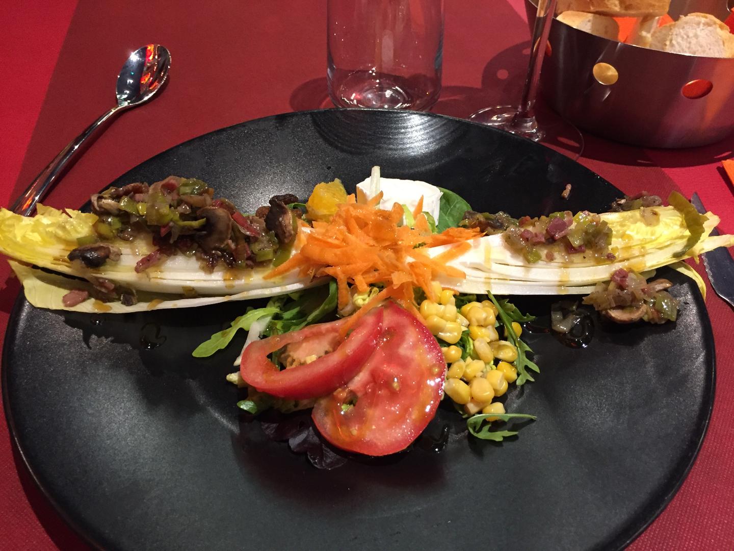 Ensalada de endibia con salteado de champiñones y jamón emplatada