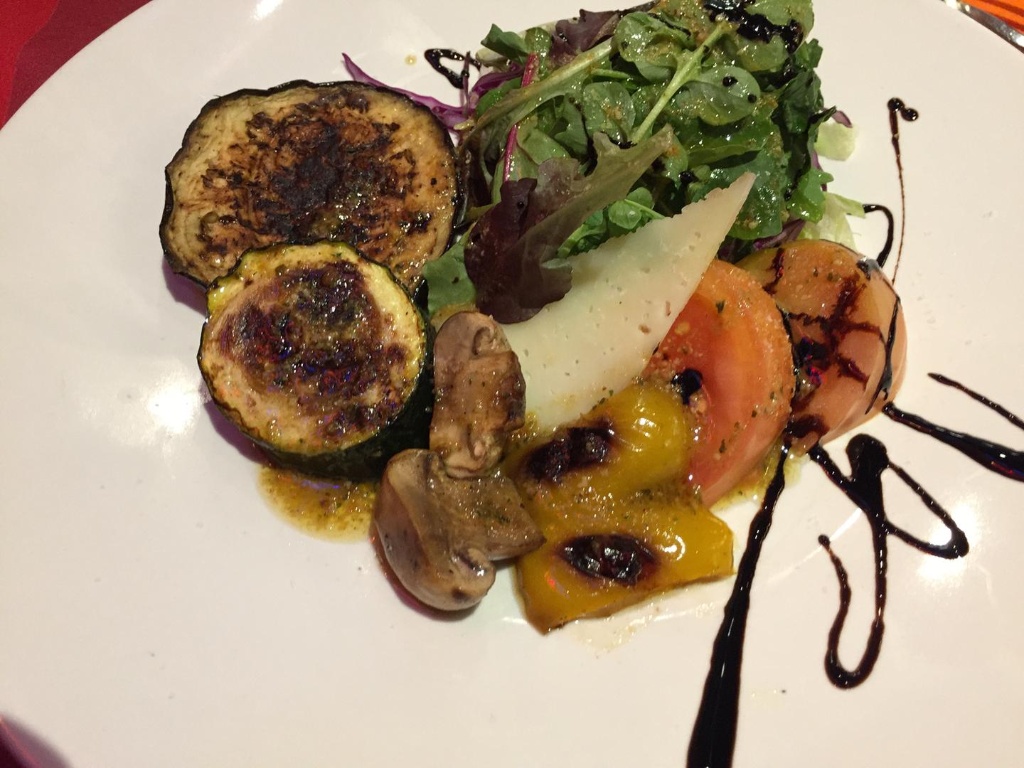 Ensalada tibia de verduras asadas con queso y reducción balsámica emplatada