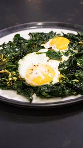 Huevo poché sobre cama de espinacas salteadas