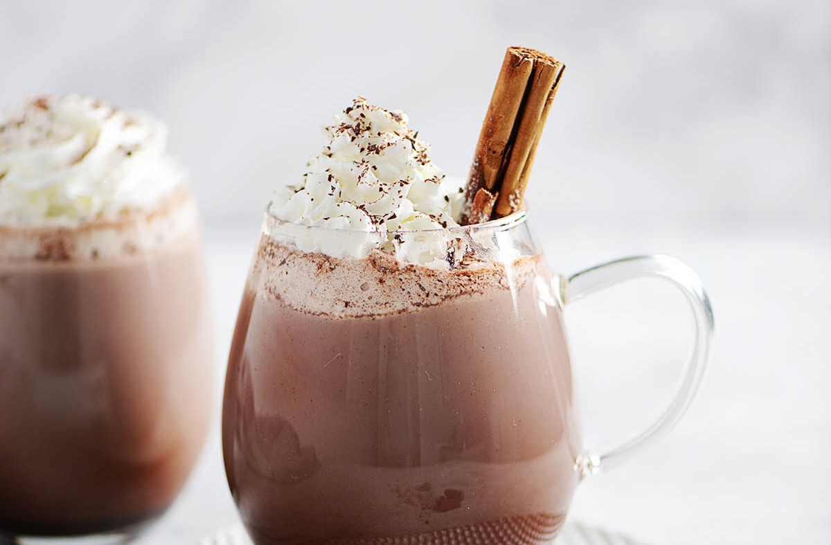 Taza de chocolate caliente mexicano con espuma y canela