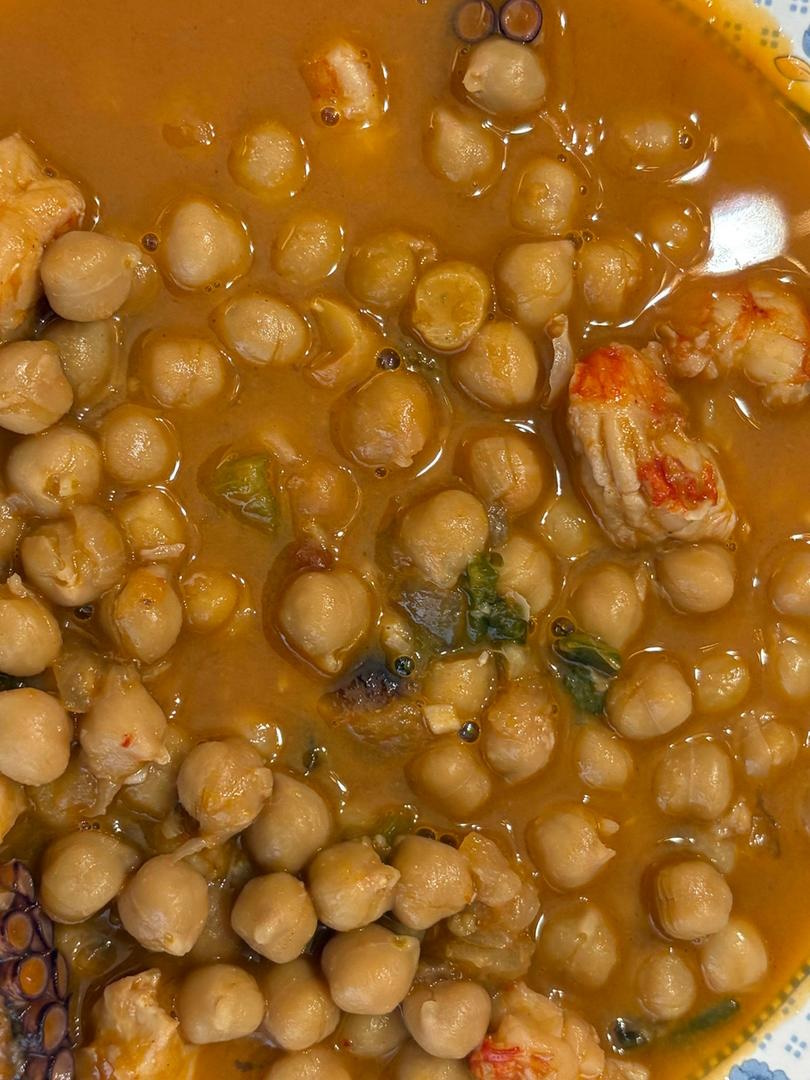 Plato de garbanzos con pulpo y gambas en un banner
