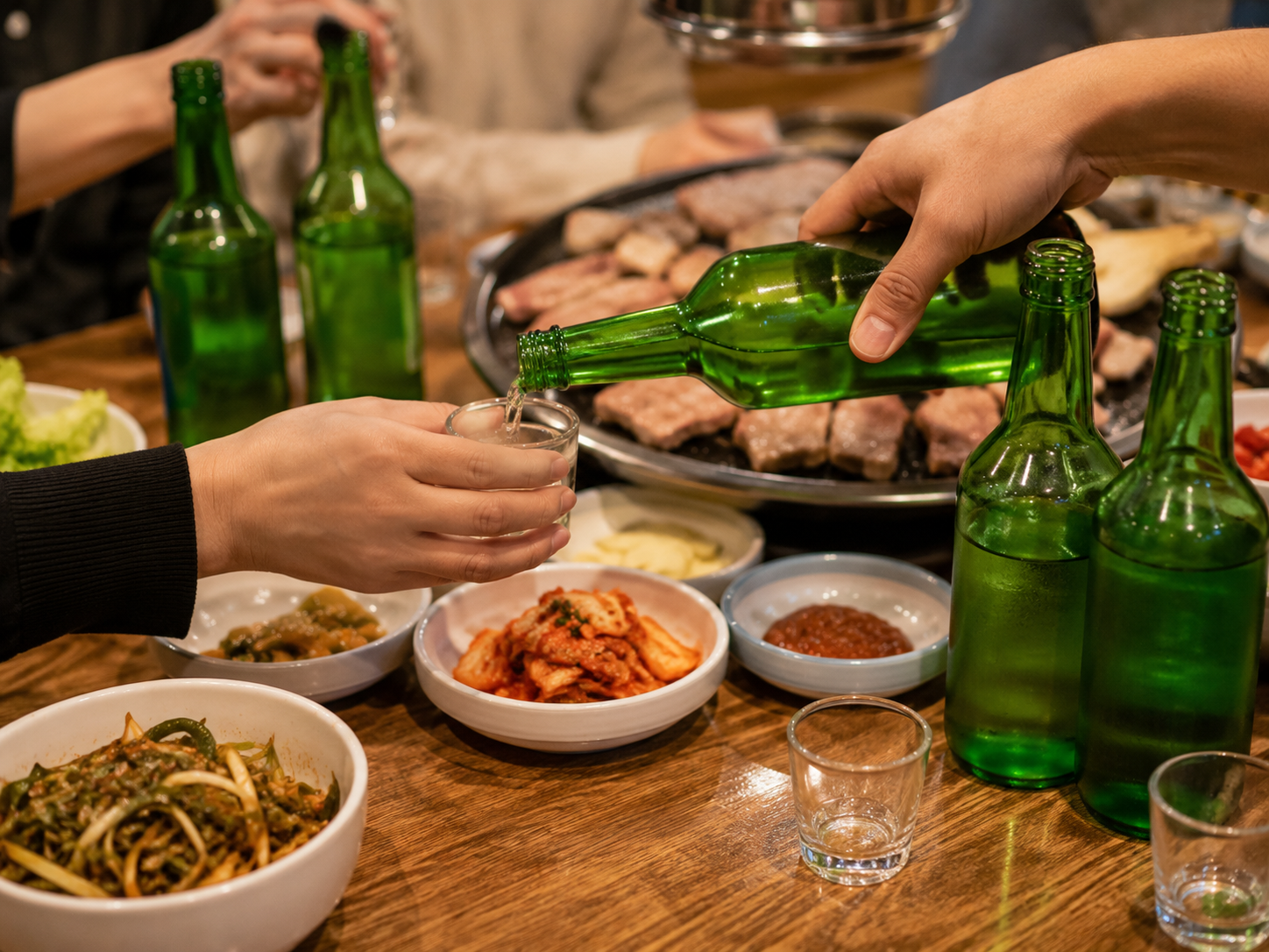 Brindis con soju en una mesa coreana compartida