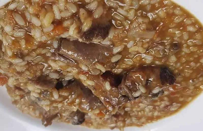 Arroz meloso de rabo de toro servido en cazuela, con trozos de rabo deshaciéndose y arroz con textura sedosa
