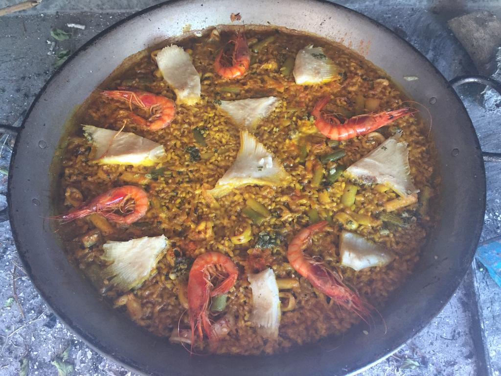Paella de raya, calamar y gambas mostrando las diferentes texturas marinas sobre arroz dorado