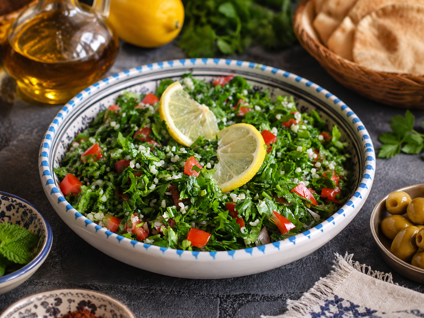 Tabulé libanés servido con perejil, tomate, bulgur, menta, limón y pan pita